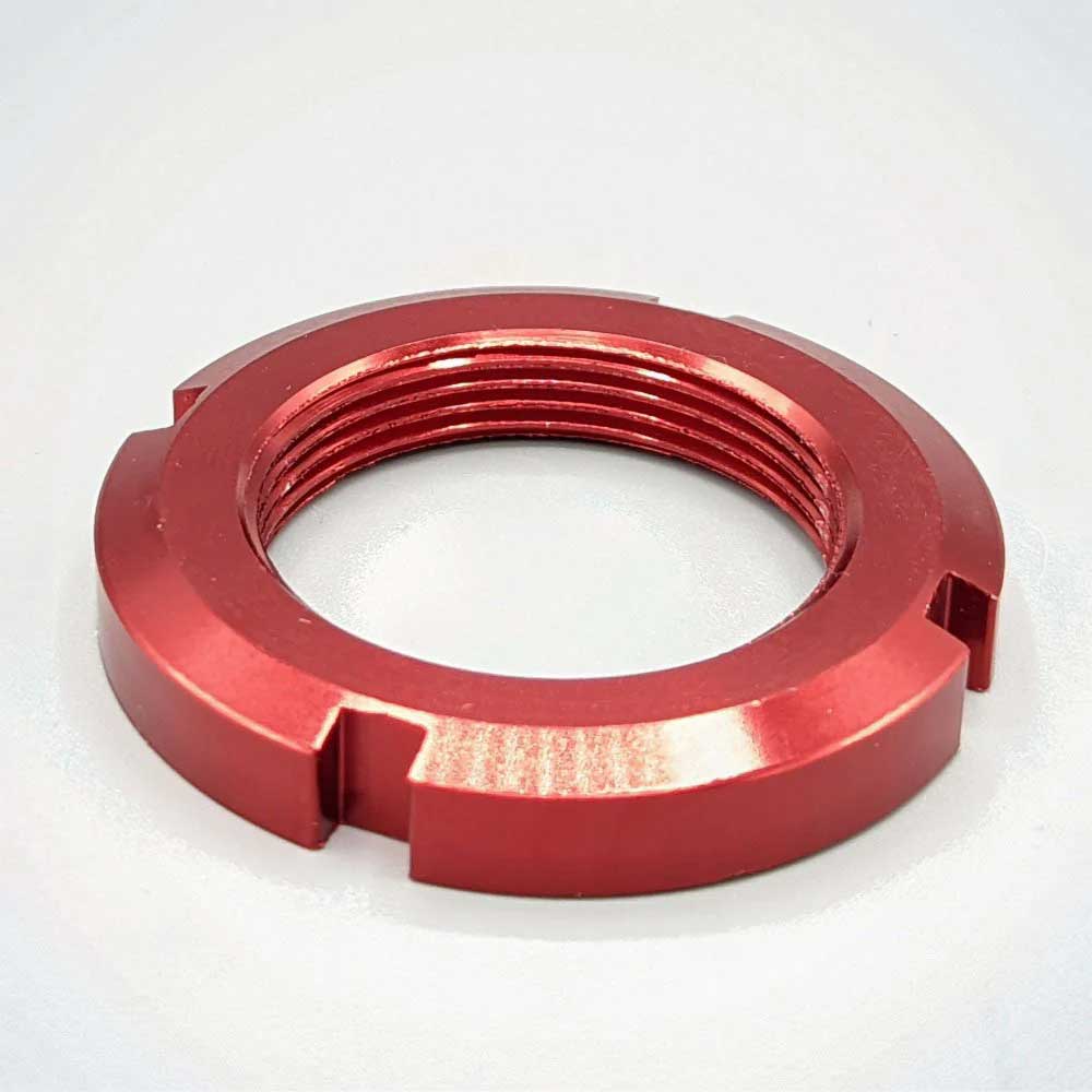 A red headset lock nut for Dualtron scooters, with visible threaded section and grooves for a tool.